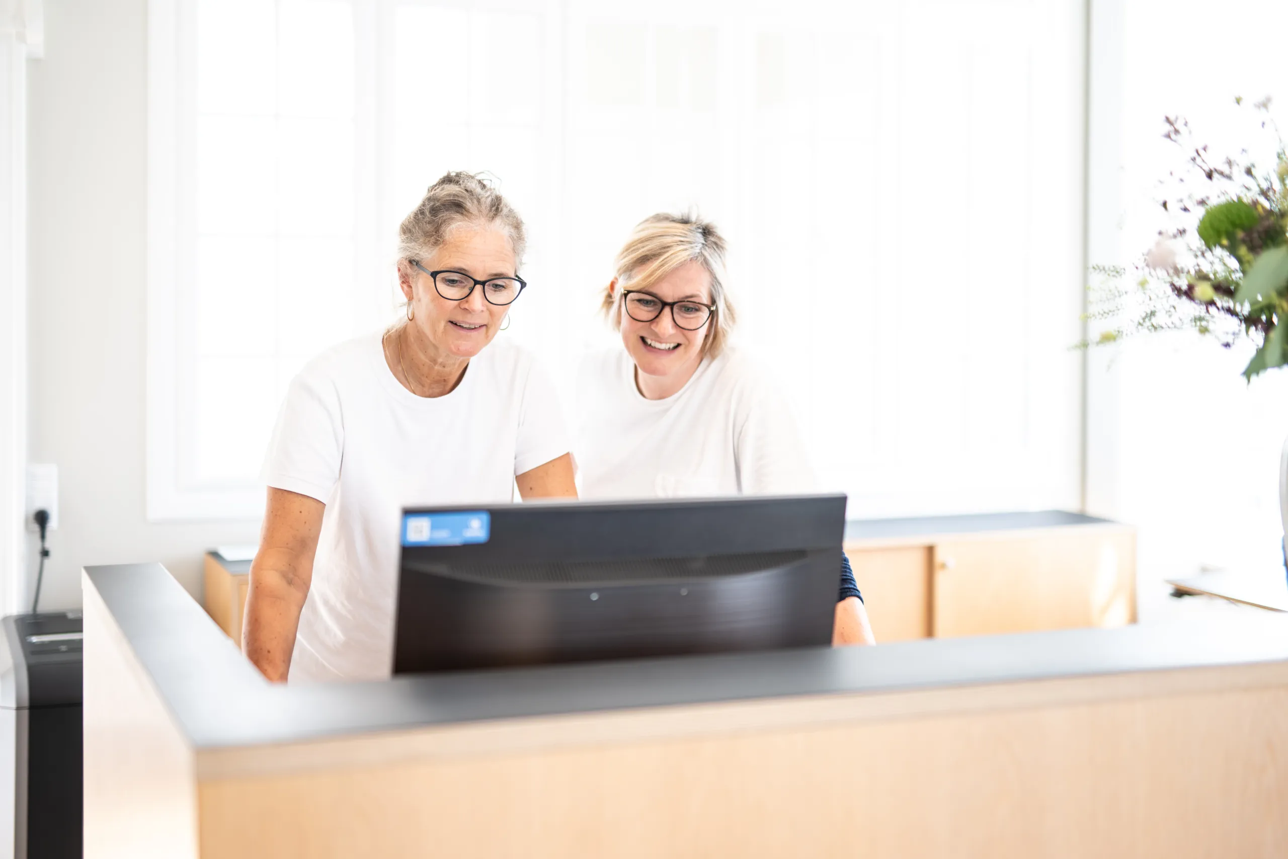 Tandlæge og receptionist vidensdeler og hjælper hinanden hos Tandlægerne Fredensborghus.