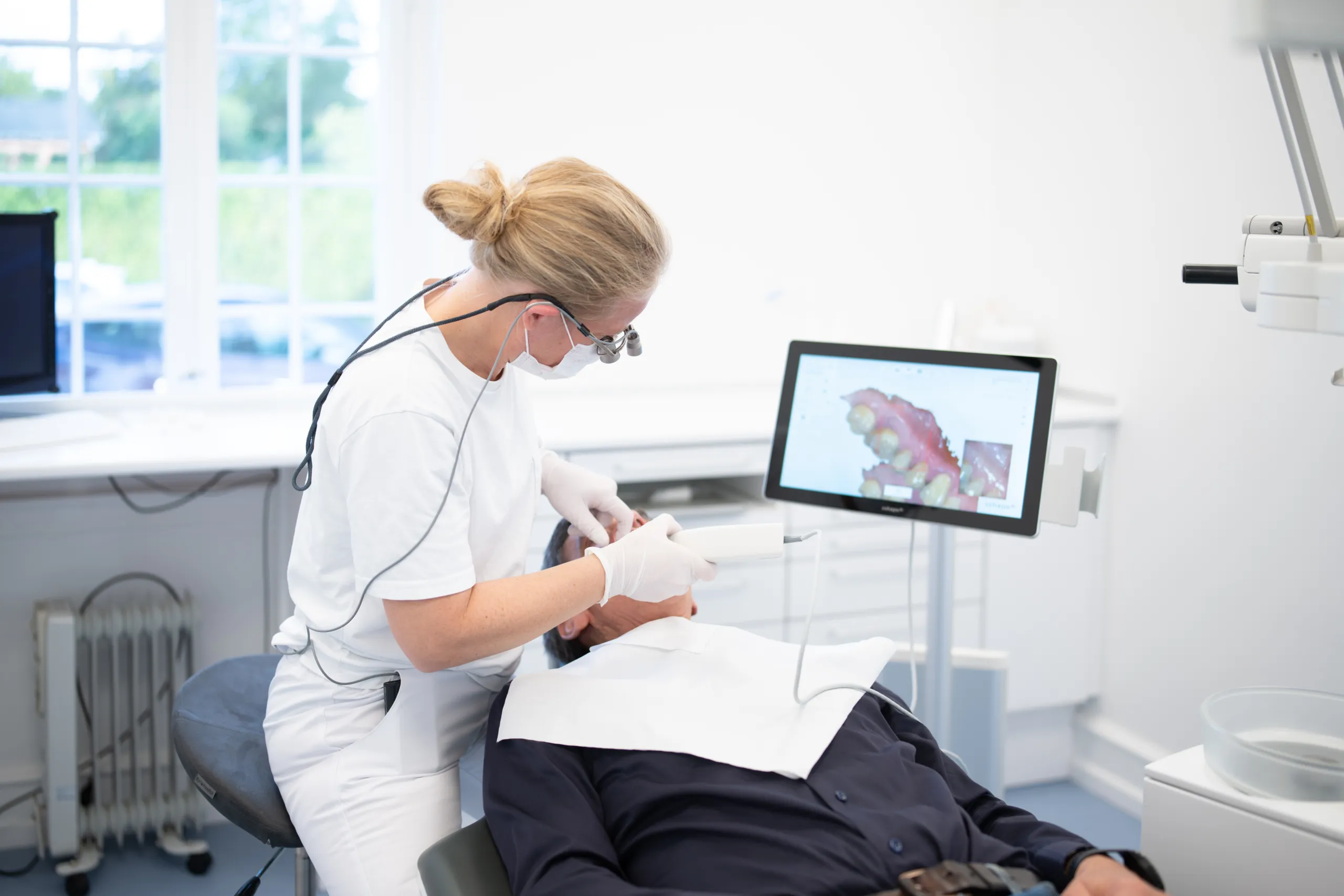 Tandlæge scanner tænder på patient med avanceret 3D teknik i stedet for aftryk.